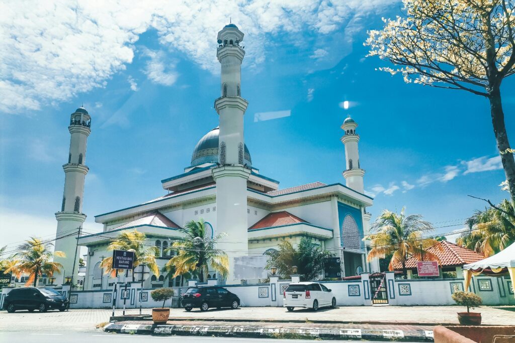 A stunning mosque with tall minarets and a dome on a clear sunny day.